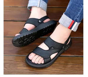 Details van zwarte lederen sandalen met NEW-logo op zachte zool en dubbele bandjes