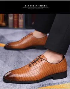 Dettaglio scarpe eleganti in pelle marrone con trama a coccodrillo e lacci classici