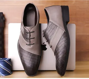 Detail of gradient brown leather dress shoes with crocodile texture on a business desk