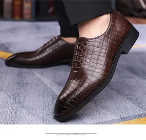 Dettaglio di scarpe da lavoro marrone scuro con elegante trama in coccodrillo