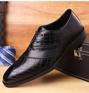 Detail of black leather business shoes with crocodile pattern texture and lace-up design