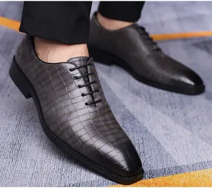 Dettaglio della trama a coccodrillo e punta in vernice su scarpe eleganti da uomo