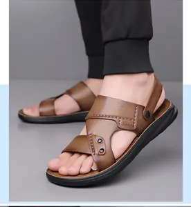 Detail van bruine leren sandalen met kruisbandontwerp en Sport-logo in reliëf