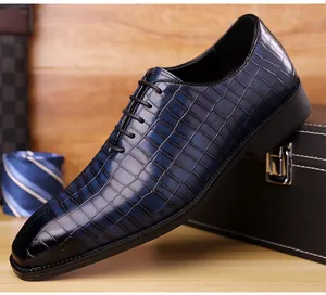 Dettaglio scarpa stringata blu scuro in pelle con trama a coccodrillo e finitura lucida