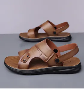 Detail van bruine leren sandalen met verstelbare hielband en antislipzool textuur