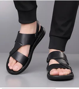 Detail van zwarte heren sandalen van leer met verstelbare hielband aan de voet gedragen
