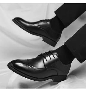 Detail of black leather brogue shoes showing wingtip carving and scale embossed texture