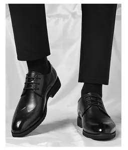 Detail of black wingtip brocade business shoes with crocodile pattern texture and laces