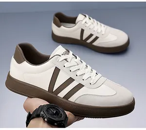 Detail van witte herensneakers met bruine strepen en een dikke rubberen zool