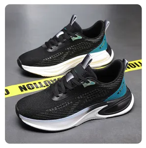 Close-up of black mesh running shoes with teal accents and cushioned sole on a grey floor