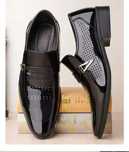 Détail macro de mocassins en cuir verni noir avec perforations Brogue et boucle dorée