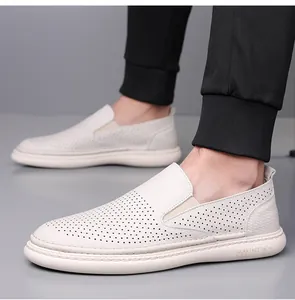 Close-up of white leather loafer with perforated surface and elastic strap on the side