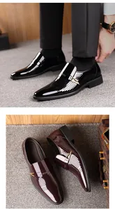 Détail de chaussures business en cuir verni perforé avec boucle métal et bout pointu