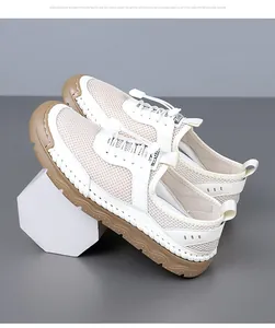 Gros plan de baskets en maille blanche avec semelle en caoutchouc marron et coutures