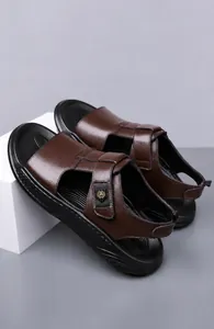Detail of dark brown leather beach sandals for men featuring a metallic gold logo buckle