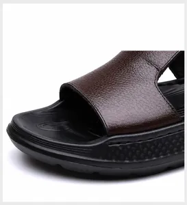 Close-up of brown leather texture and anti-slip rubber sole on men's beach sandals