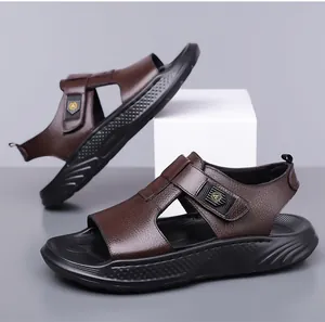Close-up of brown litchi grain leather straps and golden logo detail on men's beach sandals