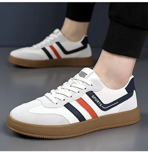 Vista dettagliata delle sneakers da uomo in pelle bianca con strisce arancioni e blu