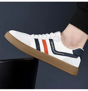 Dettaglio delle sneakers bianche casual con strisce blu-arancio e suola in gomma