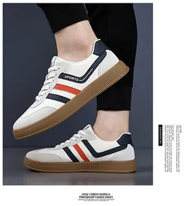 Dettaglio di sneaker bianche con strisce blu e arancioni e suola in gomma marrone