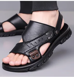Close-up of black leather sandals for men featuring metal buckles and durable rubber soles
