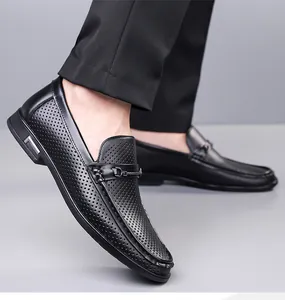 Détail de mocassins en cuir noir perforés au laser avec boucle métallique élégante