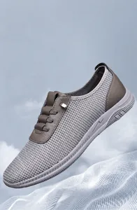 Détails macro du tissu en mesh gris respirant et coutures en cuir sur la chaussure