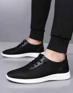 Vue portée des chaussures de sport noires respirantes pour hommes à semelle blanche
