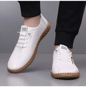 Detail showing the white synthetic leather upper and contrast stitching on the rubber sole