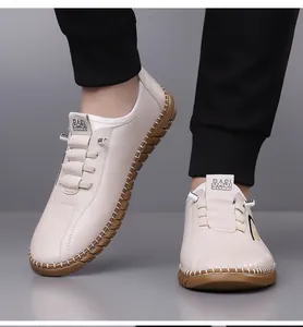 Close-up of cream leather slip-on loafers with decorative laces and brown gum sole