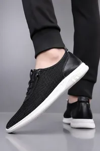 Détail de baskets en mesh pour hommes avec finitions cuir et semelles blanches