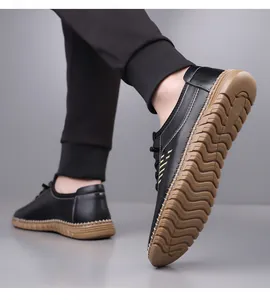 Detail showing non-slip wave texture on brown rubber sole of black leather loafer