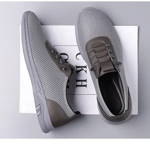 Détail de chaussure homme en mesh gris avec finitions en cuir brun et semelle en gomme