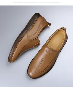 Detalle de mocasines de cuero marrón claro con costuras decorativas y suelas de goma