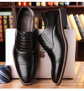 Detailed view of black leather brogue shoes with classic wingtip punching on office desk