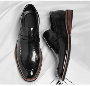 Detailed top view of black leather penny loafers with elegant glossy finish and brown trim