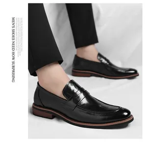 Detail of black penny loafers with glossy leather and brown textured soles for men