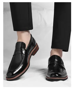 Detail shot of black patent leather penny loafers with polished finish and brown sole trim