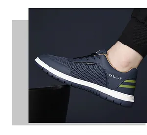 Detailed close-up of breathable navy blue mesh sneakers with green stripes and fashion text