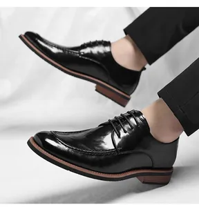 Primer plano de zapatos formales de cuero negro pulido con costuras clásicas moc-toe