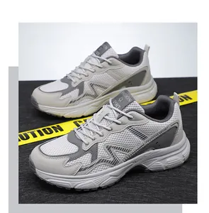 Detail of breathable grey mesh sneakers with thick white soles on urban caution tape