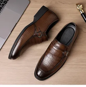 Close-up of brown crocodile embossed leather monk strap shoe on professional business desk