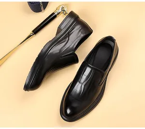 Detailweergave van zwarte leren loafers met geruite textuur en zakelijke accessoires