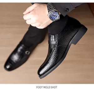 Close-up of black leather business shoes featuring textured crocodile embossing and sleek strap
