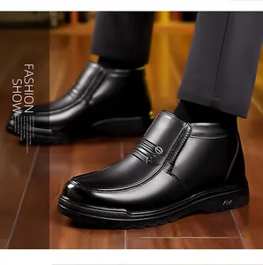 Detail of black leather men's winter boots with metal buckle on wood floor