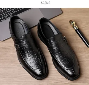 Top view of black crocodile pattern leather dress shoes with metal buckle on wood