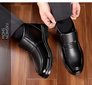 Men's black waterproof leather boots with warm lining and non-slip soles on dark wood floor