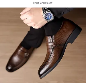 Close-up of brown textured leather dress shoes for men with side buckle and crocodile pattern