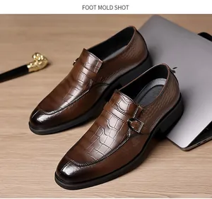 Detail of brown monk strap leather shoes with crocodile texture and gradient toe