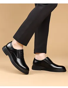 Scarpa classica Derby in pelle nera indossata con pantaloni eleganti su sfondo neutro
